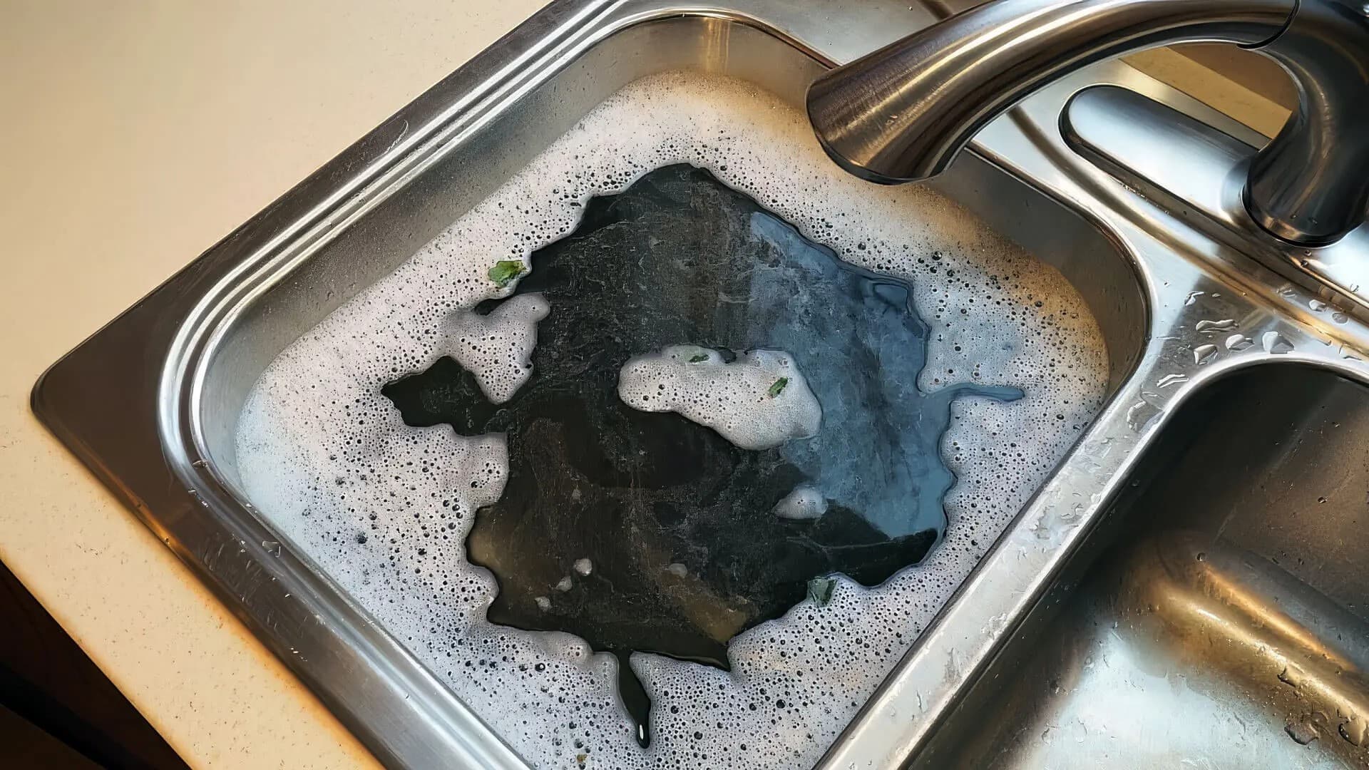 Blocked kitchen sink with dirty water.